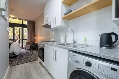 a kitchen with a sink and a washing machine at Lemon Rind - 16 Eikehoff in Stellenbosch