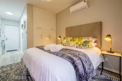 a bedroom with a large bed with two towels on it at Lemon Rind - 16 Eikehoff in Stellenbosch