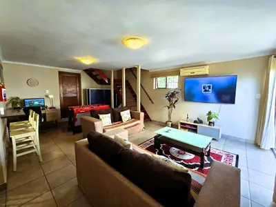 a living room with a couch and a table at Walters Lane Deluxe Garden Apartment 3 - No loadshedding in Cape Town