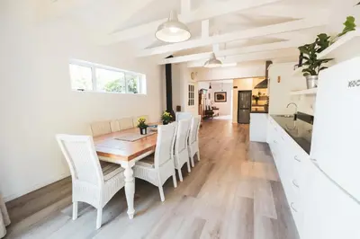 a kitchen and dining room with a wooden table and chairs at Birdsong in Hermanus