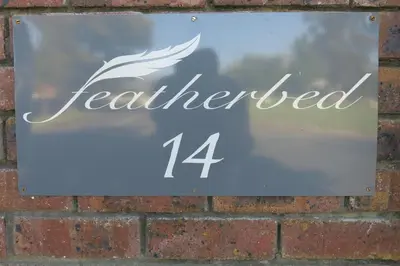 a sign on a brick wall that readsemedemed at Featherbed in Somerset West
