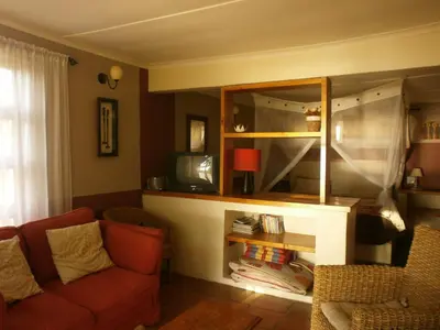 a living room with a couch and a mirror at Mooi Bly in Paarl