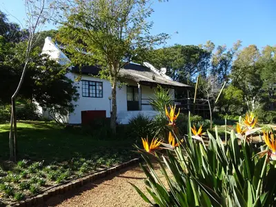 a white house with flowers in the yard at Mooi Bly in Paarl
