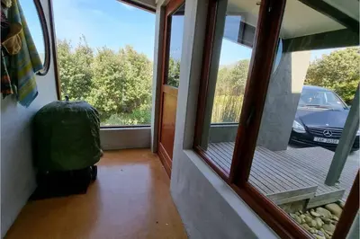 a room with a window with a view of a car at Hilltop Heaven, Walk to beach, Pool, Ocean & River views in Pringle Bay