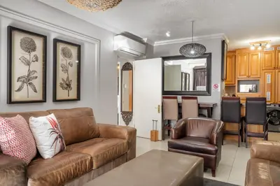 a living room with a couch and a table at Avemore Jan Cats No 5 full backup power in Stellenbosch