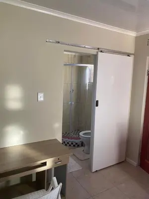 a bathroom with a toilet and a door to a room at SABATH LODGE in Cape Town