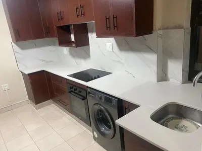 a kitchen with a washing machine and a sink at SABATH LODGE in Cape Town