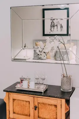 a table with glasses and a mirror on a wall at Diamant Estate in Paarl