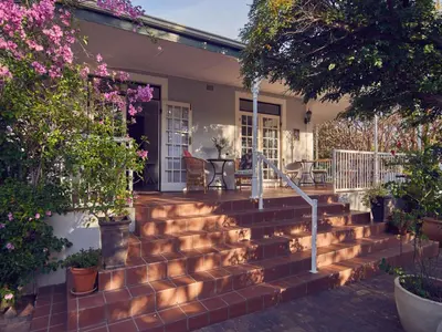 a set of stairs in front of a house with flowers at Corner House Residence in Franschhoek