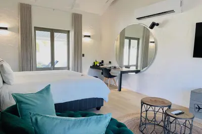 a bedroom with a large bed and a mirror at Droom Guesthouse in Franschhoek