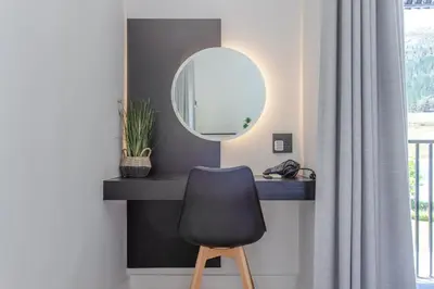 a mirror and a chair in a room at Droom Guesthouse in Franschhoek