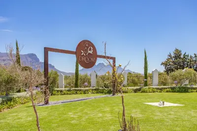 a sign in the middle of a grass field at Droom Guesthouse in Franschhoek