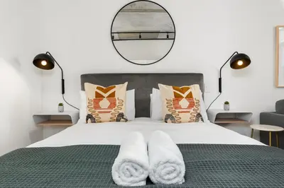 a bedroom with a bed with white towels on it at Bridgewater One Apartments in Cape Town