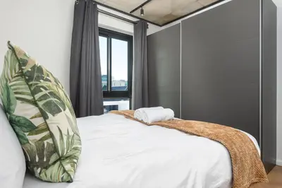 a bedroom with a bed with a pillow and a window at Bridgewater One Apartments in Cape Town