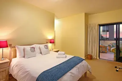 a bedroom with a large bed and a large window at Knightsbridge 407 by Host Agents in Cape Town