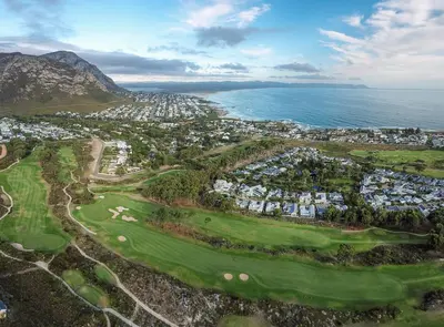 an aerial view of a golf course next to the ocean at Tuis en Tevrede - 2 Bedroom Flat in Hermanus