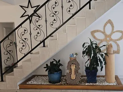 a stair rail with plants on a shelf under a staircase at Villa Parisienne Modern Guest house in Cape Town