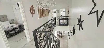 a room with a staircase with arrows on the wall at Villa Parisienne Modern Guest house in Cape Town