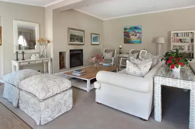 a living room with a white couch and a table at 19th Hole Guest Lodge - Golfers paradise in Hermanus