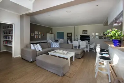 a living room with a couch and a table at 19th Hole Guest Lodge - Golfers paradise in Hermanus