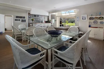 a dining room with a glass table and chairs at 19th Hole Guest Lodge - Golfers paradise in Hermanus
