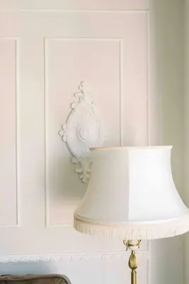 a white wall with a lamp and a white vase at Bright and airy Parisian Gem close to the beach in Cape Town
