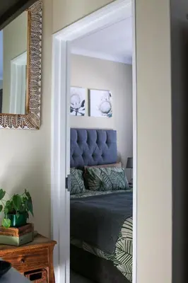 a bedroom with a bed and a mirror at The Jade Somerset West in Cape Town