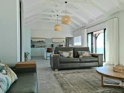 a living room with a couch and a table at The Anchor, Luxury living for 2 with sea view and Jacuzzi in Gordonʼs Bay