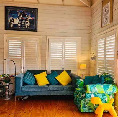 a living room with a blue couch with yellow pillows at Exquisite chalet on private nature reserve in Wolseley