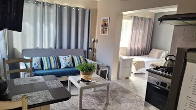 a living room with a blue couch and a table at Senelle accomodation in Hermanus