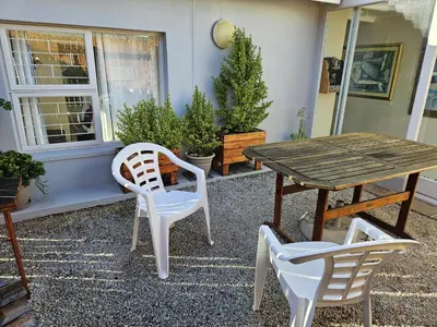 a table and two chairs and a wooden table and chairs at Senelle accomodation in Hermanus