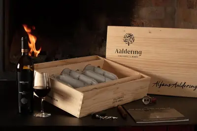 a wooden box with a bottle of wine and a glass at Aaldering Luxury Lodges in Stellenbosch