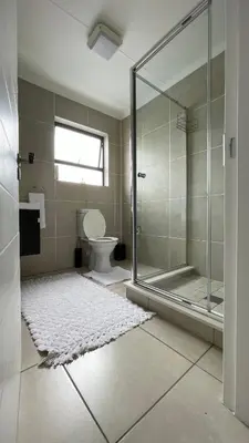 a bathroom with a glass shower and a toilet at 417 The Sandown in Cape Town