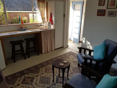 a living room with a chair and a table at The Hermitage in Cape Town