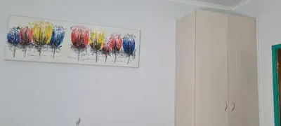 a painting hanging on a wall next to a cabinet at Ojong's Court Bellville in Cape Town