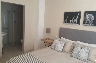 a bedroom with a bed with pillows on it at Complete self-catering apartment close to the beach in Cape Town