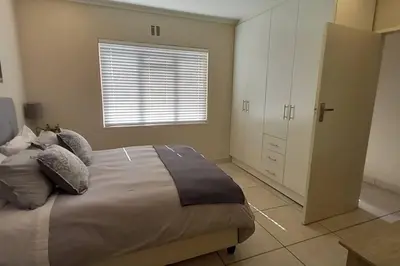 a bedroom with a large bed and a window at Complete self-catering apartment close to the beach in Cape Town