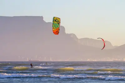 a person flying a kite in the ocean at Complete self-catering apartment close to the beach in Cape Town