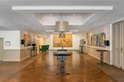 a room with paintings on the walls and a table at Lord Charles Hotel, Somerset West, a Tribute Portfolio Hotel in Somerset West