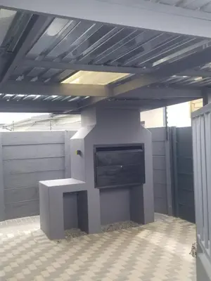 a room with a table and a tv on a wall at Prince Olive in Cape Town