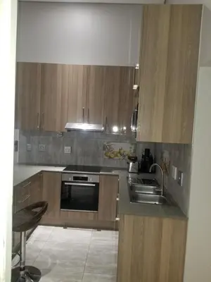 a kitchen with wooden cabinets and a sink at Prince Olive in Cape Town