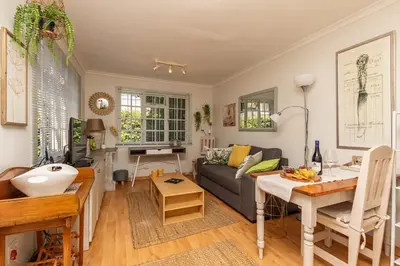 a living room with a couch and a table at Suburban bliss with Wifi and plunge pool in Cape Town