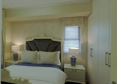 a bedroom with a bed and two night stands with lamps at Century City Mayfair Luxury Apartments in Cape Town