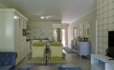 a kitchen with two chairs and a table in it at Century City Mayfair Luxury Apartments in Cape Town