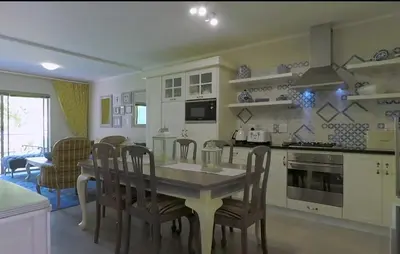 a kitchen with a table and chairs and a dining room at Century City Mayfair Luxury Apartments in Cape Town