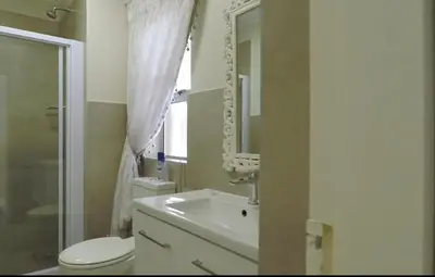 a bathroom with a sink and a toilet and a mirror at Century City Mayfair Luxury Apartments in Cape Town