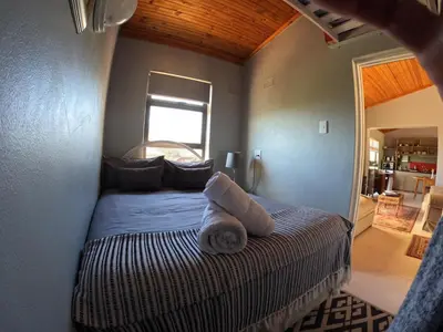a bedroom with a bed with towels on it at Edible Shores in Pringle Bay