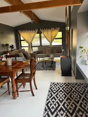 a living room with a table and a couch at Edible Shores in Pringle Bay