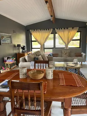 a living room with a wooden table and a couch at Edible Shores in Pringle Bay