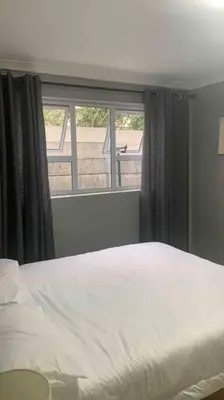 a bedroom with a white bed and a window at SpaciousNetflix#Wifi#Parking#CentralWinefarms#Mall in Cape Town